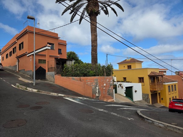 Steep corner with terracotta and yellow houses typical of El Sauzal’s hillside streets.