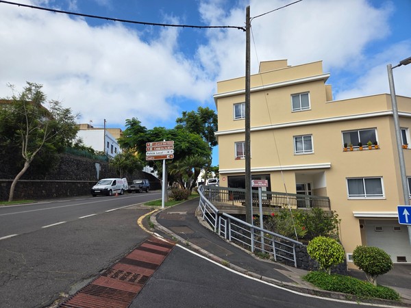 Neighborhood of white villas with gardens, a small pool and tennis court overlooking the ocean.