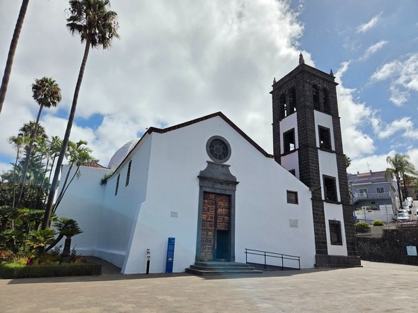 Façade of Iglesia de San Pedro in El Sauzal with whitewashed walls and a dark lava-stone bell tower.