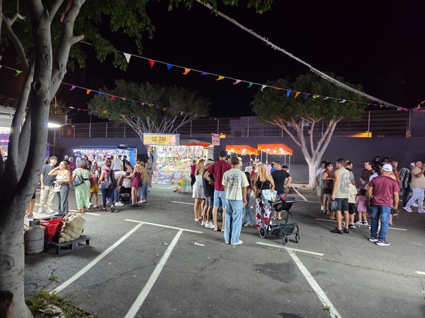 Night view of the funfair at the Fiestas de El Fraile 2025 with crowds, bunting and game stalls in Arona, Tenerife.