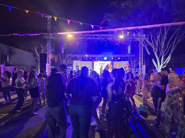 Concert with singers and an animated crowd dancing under festival lights during the El Fraile celebrations.