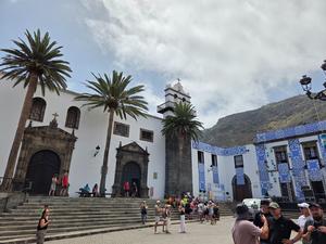 Main plaza of Garachico filled with visitors and decorated facades for a local festival.