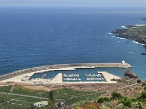 Aerial view of the marina of Garachico with boats and protective breakwaters.