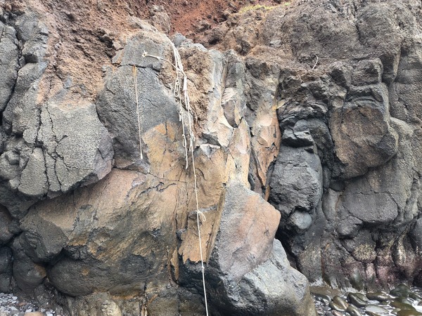 Close photo of improvised ropes fixed to a lava outcrop near Garañona, indicating hazardous, informal access.