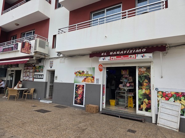 Facade of El Baratísimo grocery shop in Guaza Tenerife with fruit images and a kebab café beside it.