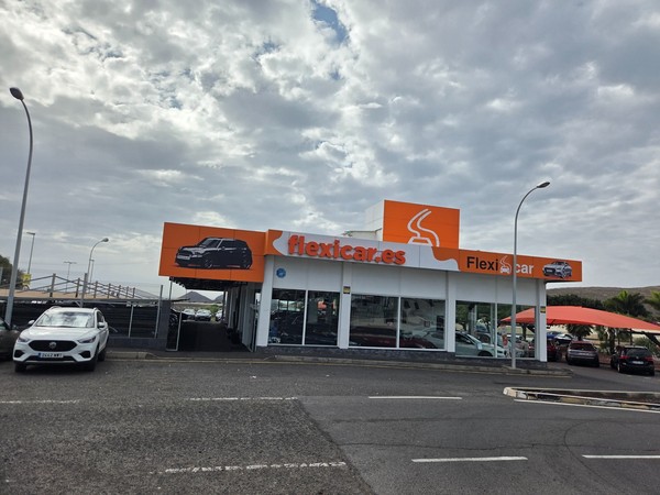 Flexicar used car dealership in Guaza Tenerife with several vehicles parked in front of the orange and white showroom.
