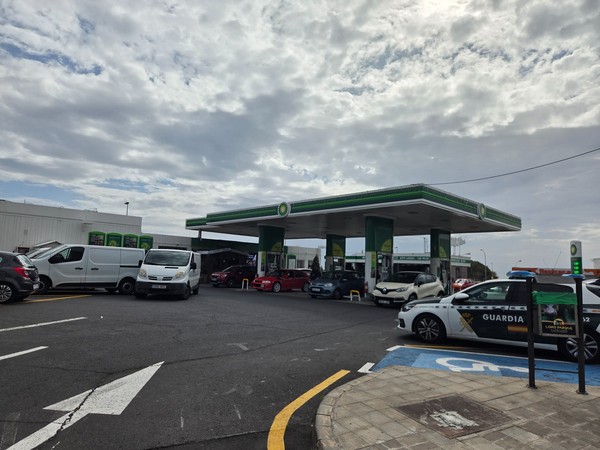 Busy BP petrol station in Guaza Tenerife with several cars refuelling and a Guardia Civil vehicle parked nearby.