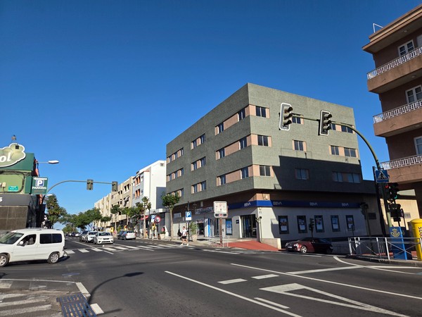 Busy crossroads in Güímar with a BBVA bank on the corner, several apartment blocks and moving traffic.