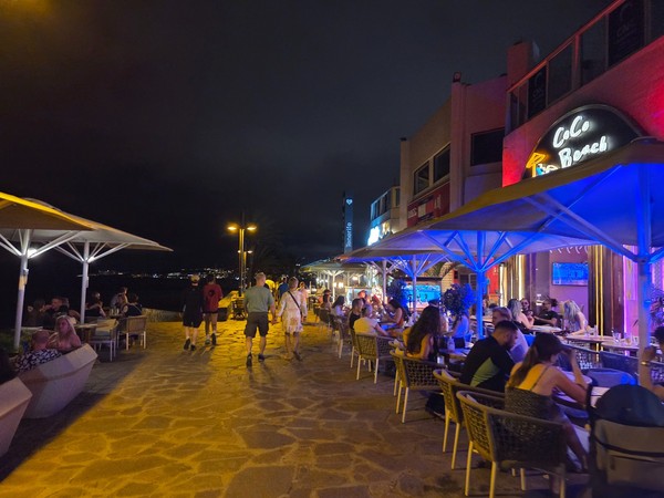 Nighttime view of seafront bars and restaurants along the promenade near Playa de las Américas and Costa Adeje.