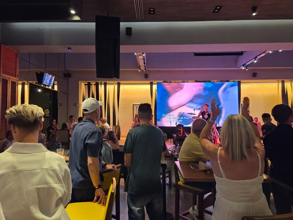 Illuminated Hard Rock Cafe Tenerife sign on a dark timber wall inside the venue.