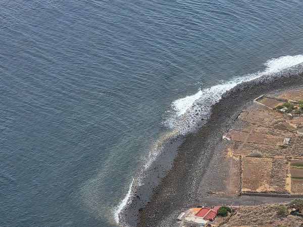 Rocky beach at Igueste de San Andres with waves curling along the shore from a high viewpoint.