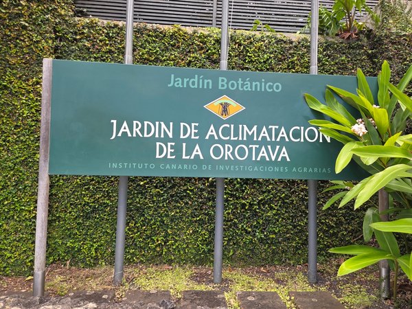 Entrance sign of the Jardín de Aclimatación de La Orotava surrounded by lush greenery.