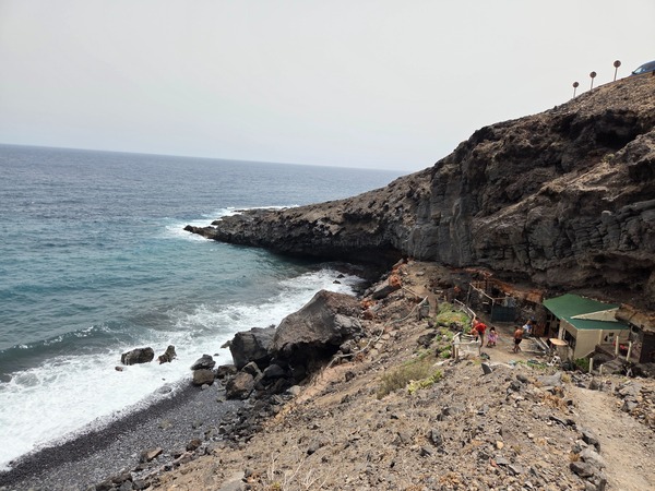 Small secluded cove near La Caleta de Punta Prieta known locally as Playa de Abajo, with a rocky shoreline and rustic huts.