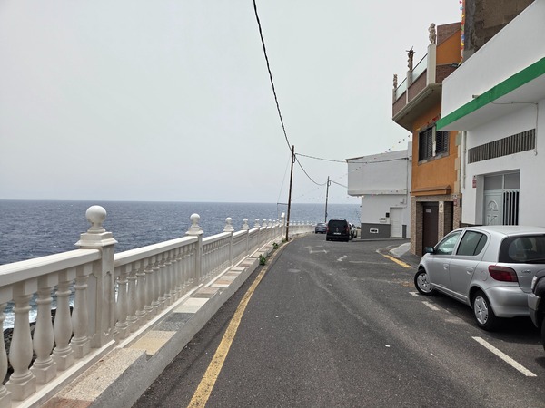 Seafront street with white balustrade and Atlantic views along the edge of La Caleta de Punta Prieta.