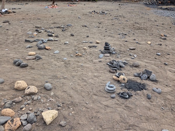 Stone letters and cairns laid out on the beach at Playa Las Galgas.