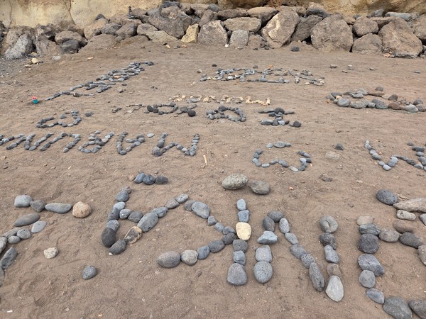 Close-up of volcanic pebbles and small stone stacks arranged on the sand.