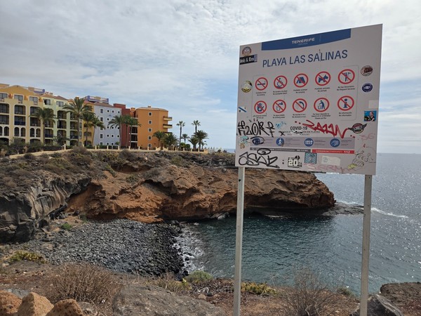 Municipal sign for Playa Las Salinas in Costa Adeje indicating no lifeguard and standard beach rules.