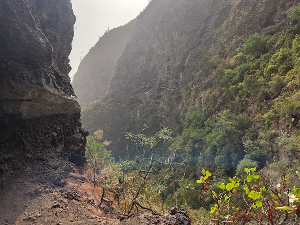 Steep ravine walls and rugged volcanic slopes surrounding the route.