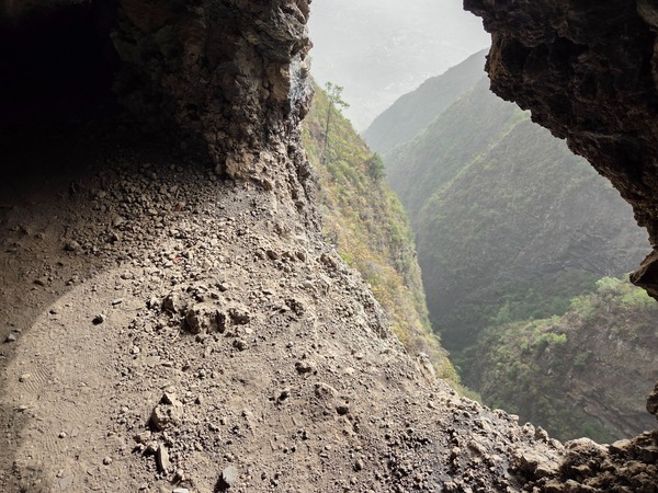 Exposed 'window' cut into the cliff with a sheer drop into the ravine below.
