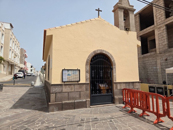 Small beige chapel with a bell tower and cross in the heart of Los Abrigos village.