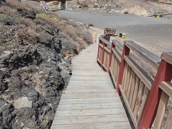Wooden walkway and steps leading down to the black-sand beach in Los Abrigos Tenerife.