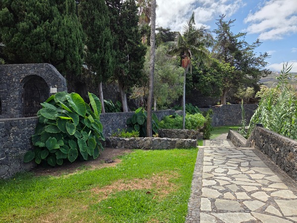 Lush terraces with lawn, stone walls and tropical plants inside Parque Los Lavaderos.