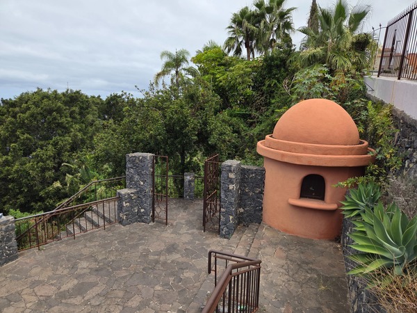 Information sign of Parque Los Lavaderos framed by palm trees and sea view.