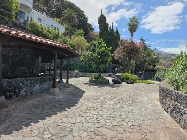 Central square beside the historic washing basins with shaded roof in Parque Los Lavaderos.