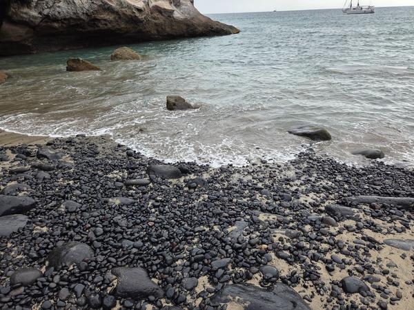 Boulders scattered in shallow water along the coast at Playa de los Morteros.
