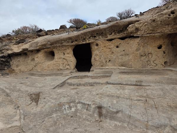 Exterior of Cueva La Tabona, a cave carved into the rocky cliff near Playa de los Morteros.