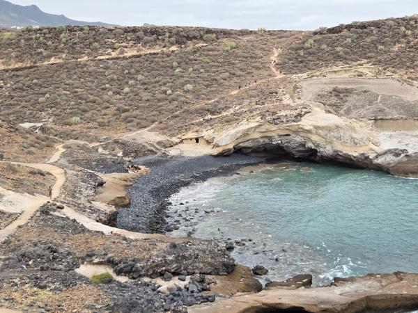 Panoramic view of Playa de los Morteros with its rocky cove and turquoise waters.
