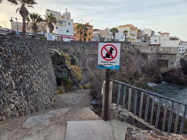 Entrance sign at Playa Méndez near Alcalá showing a prohibition for animals, located above the descent to the cove.