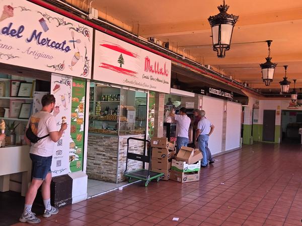 Puestos con comida libanesa e italiana artesanal y gente comprando.