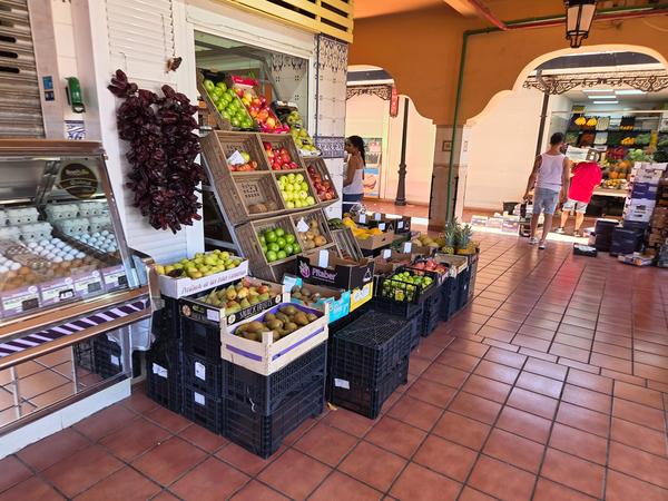 Expositor de frutas frescas con manzanas, peras y plátanos en el mercado.