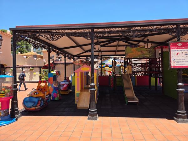Parque infantil cubierto con toboganes y juegos coloridos dentro del recinto del mercado.