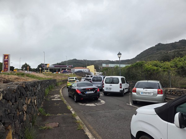 Traffic and parking area near the market entrance along the service road.