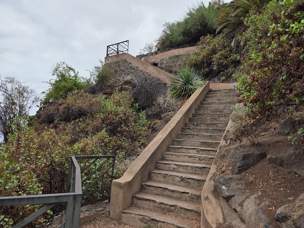 Long flight of cliff stairs climbing toward upper terraces and rock walls Long flight of cliff stairs climbing toward upper terraces and rock walls.