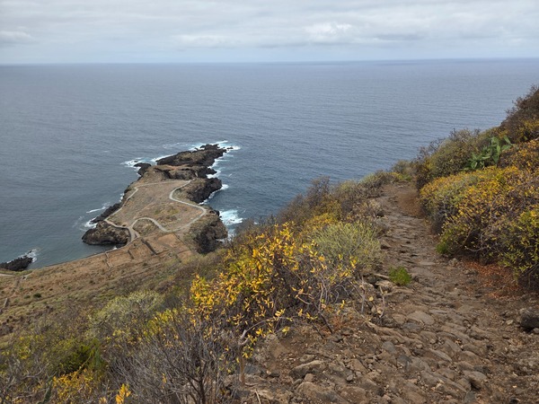 Long traverse of the cliff with terraced fields and the north coast of Tenerife in view.