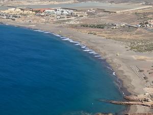 Playa de la Tejita seen from Montaña Roja, with its golden sands and gentle waves along the coastline.