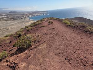 Red volcanic trail on Montaña Roja overlooking El Médano and the ocean.