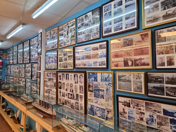Interior gallery of the Casa Museo del Pescador in Puerto de la Cruz with dozens of framed historic photographs and model boats in glass cases.