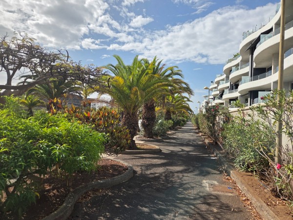 Road junction on the outskirts of Palm-Mar with cars and signposts pointing towards the resort and nearby coastal routes.