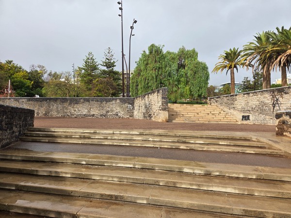 Wide stone steps and terraces inside Parque La Granja leading up between trees and palm-lined walls.