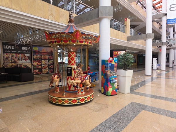 Children’s carousel with colourful horses and a prize machine in the background inside Pasarela Shopping Center in Tenerife.