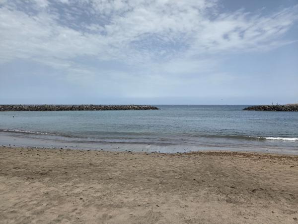Playa El Bobo shoreline with people sunbathing