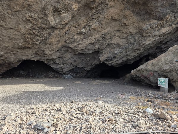 Two shallow sea caves under a lava overhang on the pebble shore at Playa Aguadulce.
