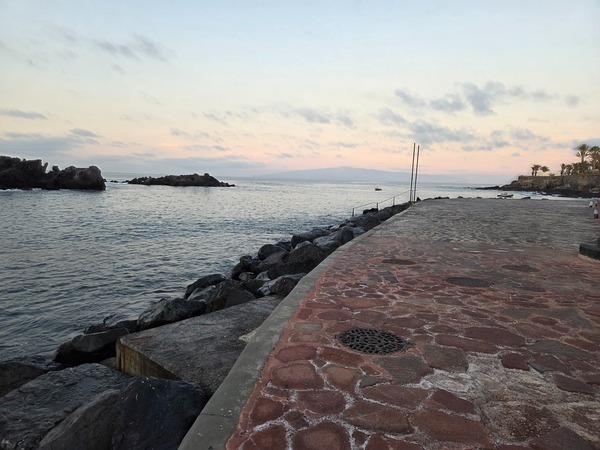 Another angle of La Playita cove showing the curve of the shoreline and volcanic formations.