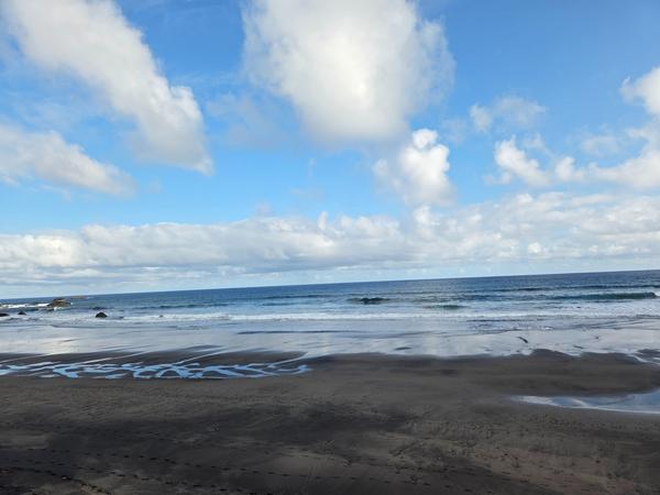 Soft morning light over Playa de Almáciga with reflections in the wet sand.