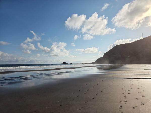 Footprints in the black sand at sunrise on Playa de Almáciga.