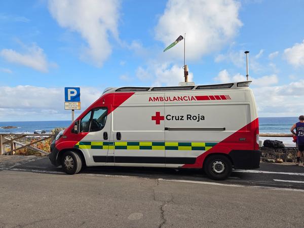 Red Cross ambulance parked beside Playa de Almáciga, ready for emergencies.